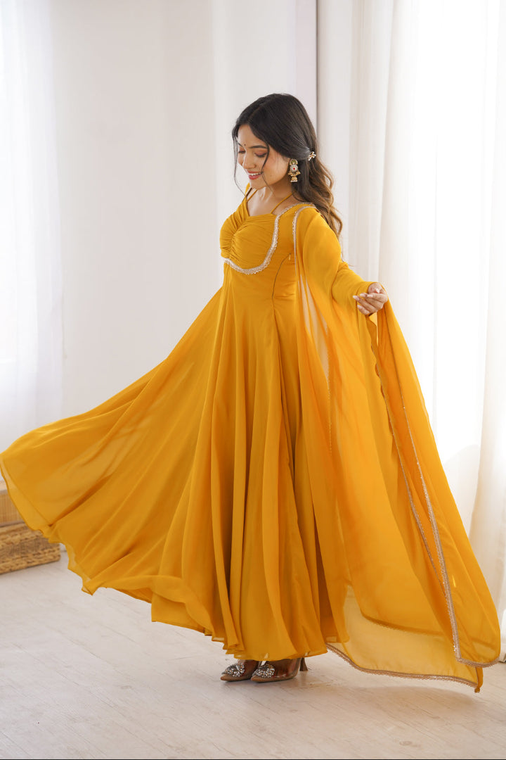 Woman in a yellow dress standing in a room with white curtains.