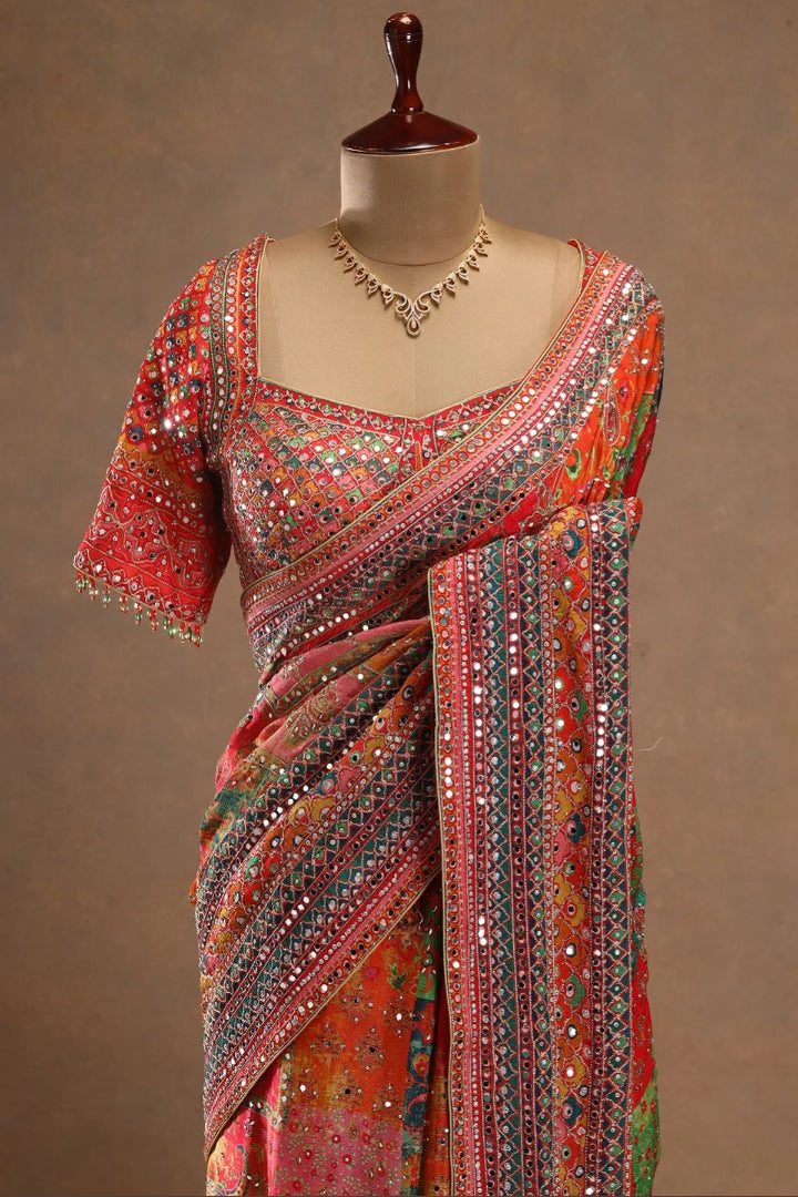 Colorful saree with intricate patterns on a mannequin against a brown background