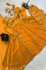 Orange traditional outfit with gold embroidery on a light gray surface