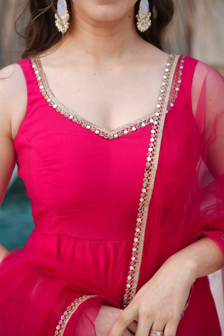 Close-up of a person wearing a bright pink traditional outfit with intricate detailing.
