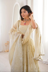 Woman in a light-colored traditional outfit with a plain white background