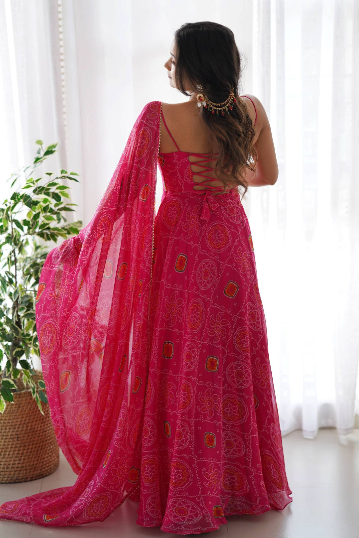 Woman wearing a bright pink saree with a white curtain and plant in the background