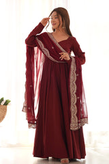 Woman wearing a maroon traditional outfit with white embroidery in a bright setting