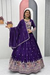 Woman in a traditional purple embroidered outfit standing in front of a mirror.