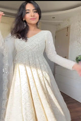 Woman wearing a white dress with long sleeves in an indoor setting
