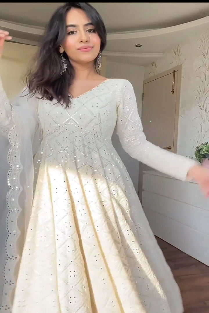 Woman wearing a white dress with long sleeves in an indoor setting