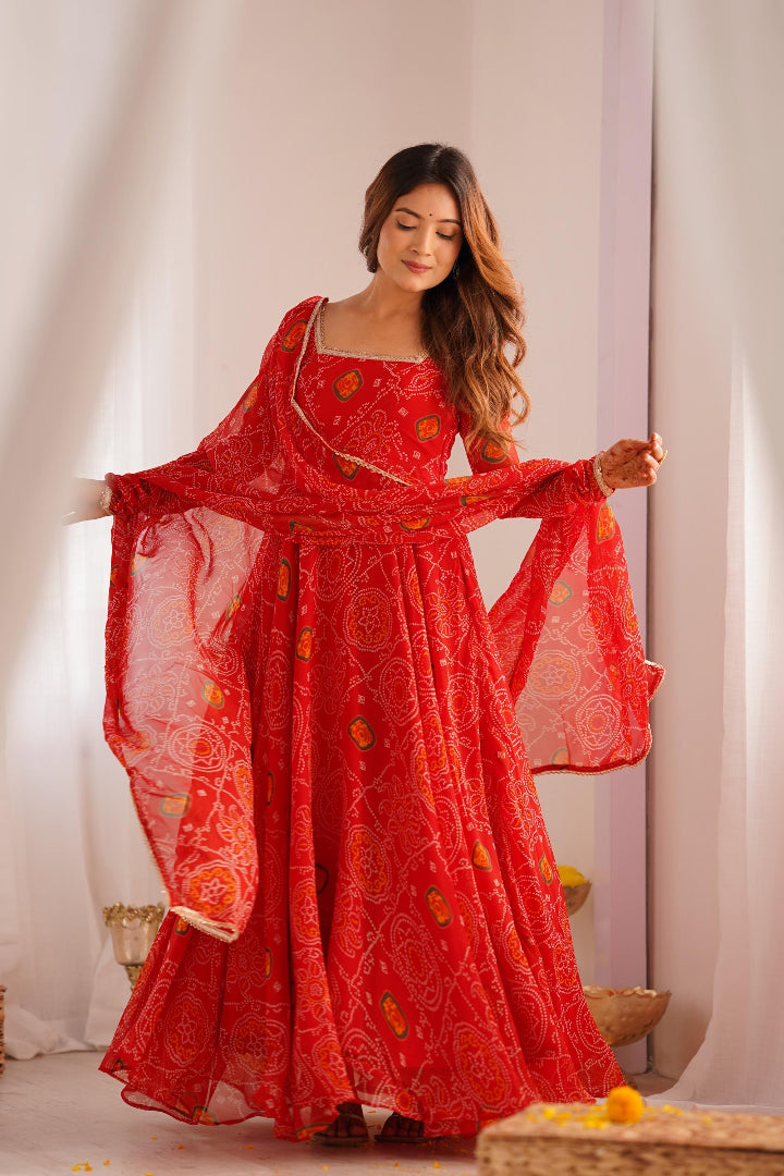 Woman wearing a red traditional outfit with a matching dupatta in a softly lit room.