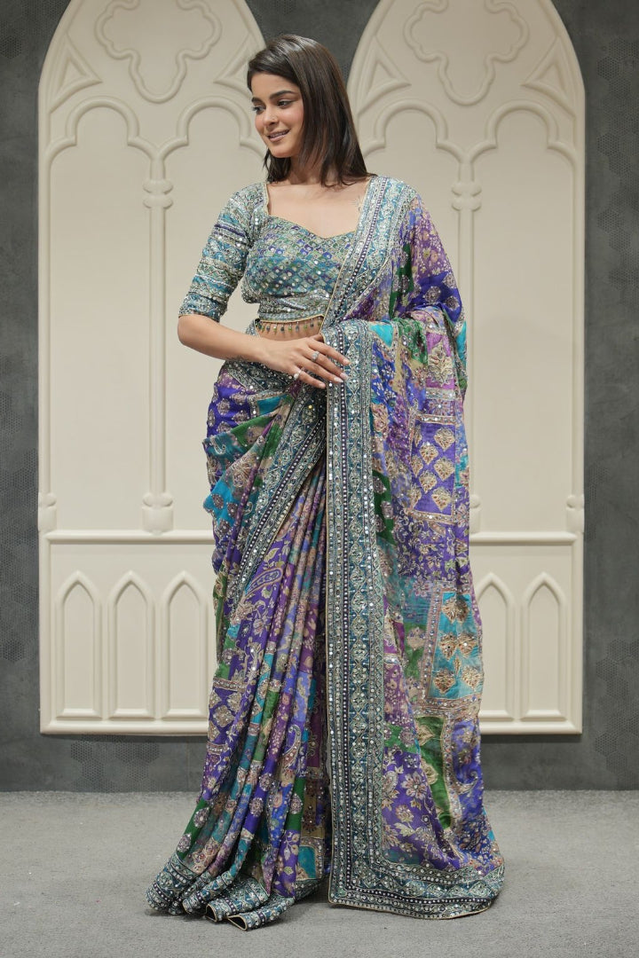 Woman wearing a colorful saree with a patterned background