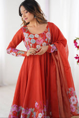 Woman wearing a red traditional outfit with floral patterns indoors.