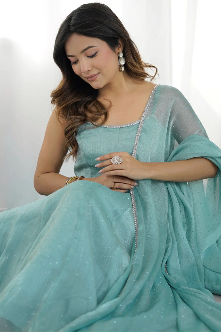 Woman wearing a light blue saree with a white background
