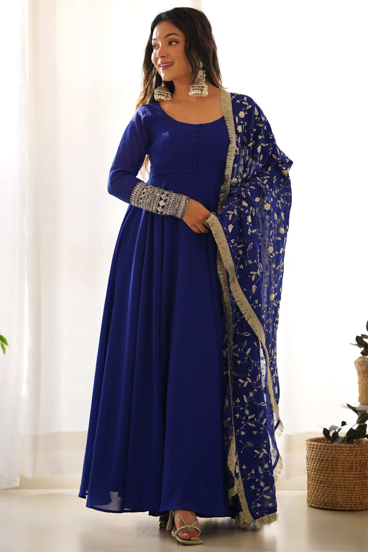 Woman in a blue traditional outfit with a matching dupatta indoors.