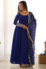 Woman in a blue traditional outfit with a matching dupatta indoors.