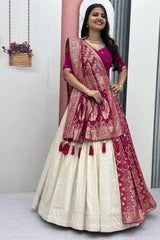 Woman wearing a traditional outfit with a pink and red dupatta in a minimal indoor setting.