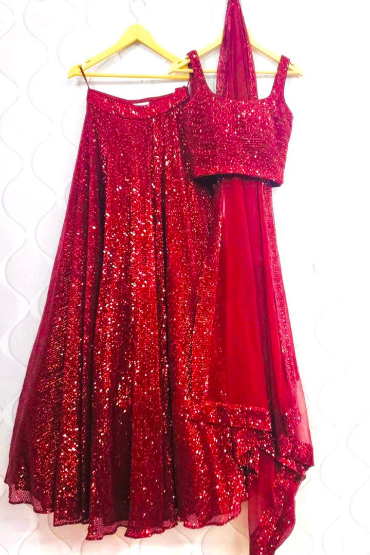 Red sequin dress on a hanger against a white background