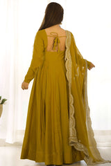 Woman wearing a mustard yellow dress with a matching dupatta on a white background