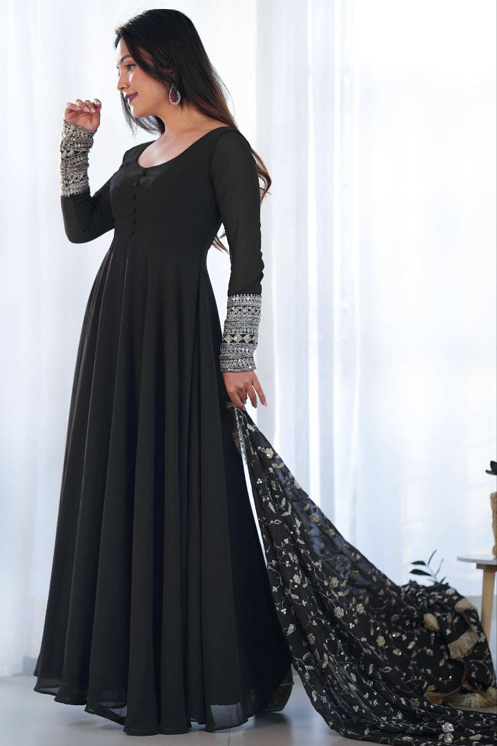 Woman in a long black dress with a flowing train against a white background