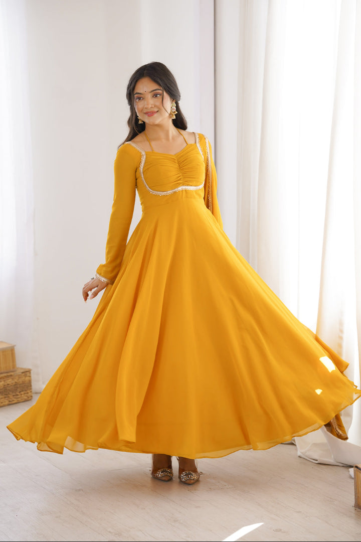 Woman wearing a yellow dress with long sleeves in a bright room.