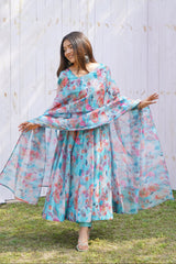 Woman wearing a floral dress with a white wooden fence and grass background