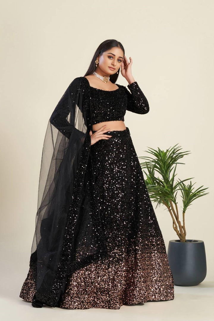 Woman in a black and gold traditional outfit with a plant in the background