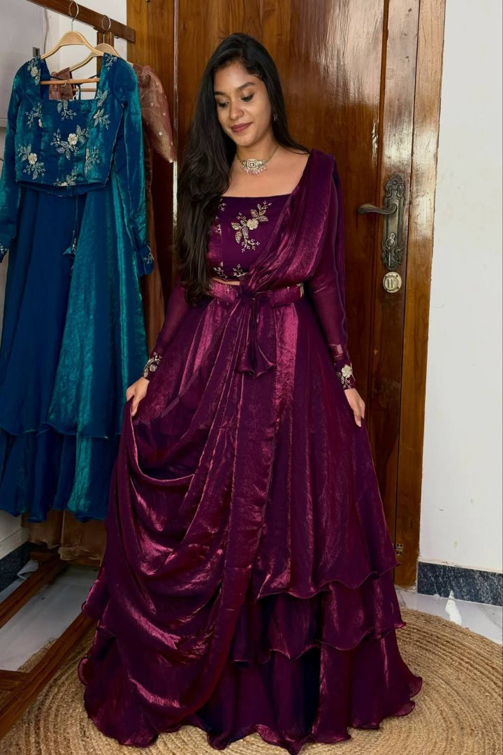 Woman in a purple gown standing next to a blue dress in a room.