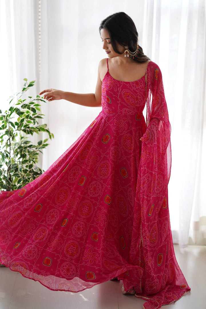 Woman wearing a pink saree with a white curtain and plant in the background