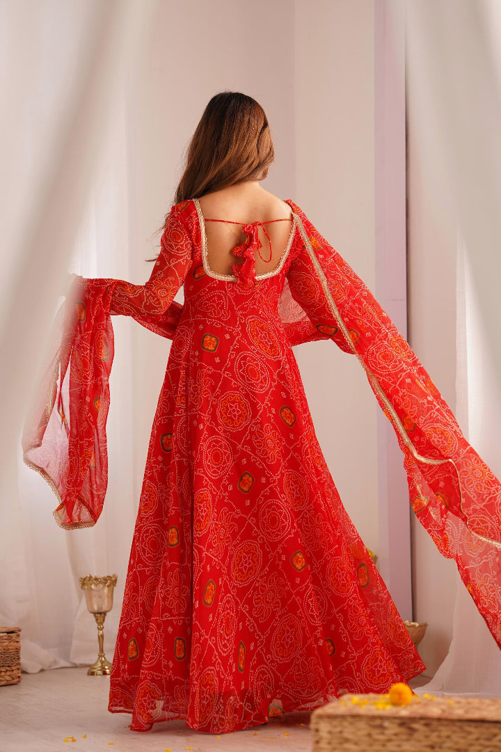 Red embroidered dress with long sleeves worn by a person, standing against a neutral background.