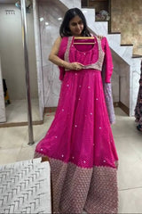 Woman trying on a pink traditional outfit in a mirror