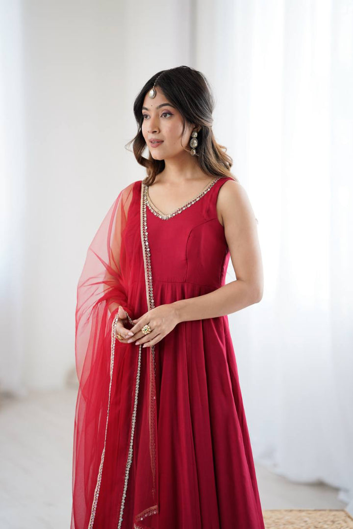 Woman wearing a red dress with a sheer dupatta in a bright room