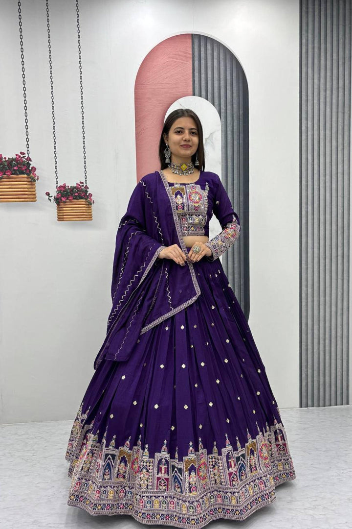 Woman in a purple embroidered traditional outfit standing in front of a mirror.