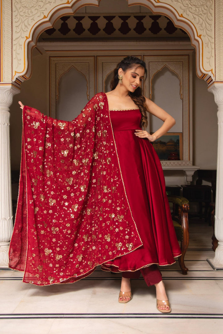 Woman in a red traditional outfit with a matching dupatta in an ornate indoor setting