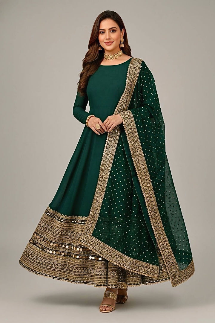 Woman wearing a green traditional outfit with gold embroidery on a gray background