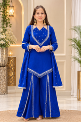 A woman modeling a royal blue traditional outfit with silver mirror-work embroidery, consisting of a long-sleeve kurta, flared pants, and a matching dupatta, set against an elegant indoor backdrop.