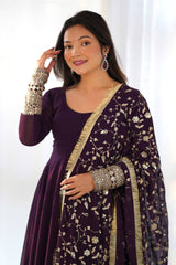 Woman wearing a purple traditional outfit with a floral patterned shawl against a white background