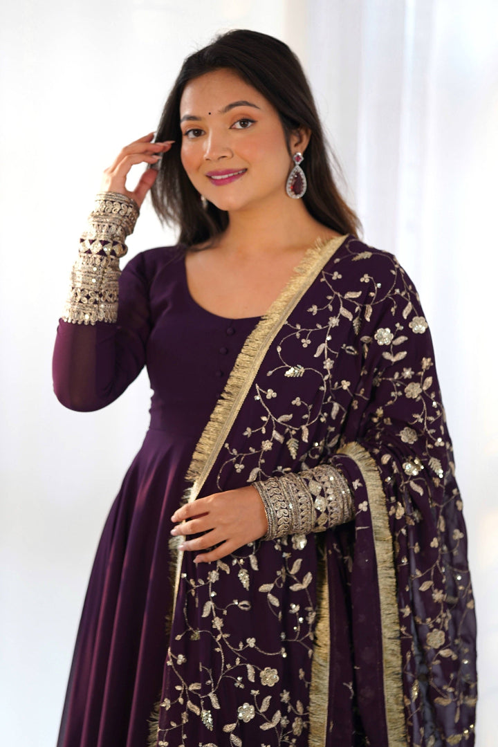 Woman wearing a purple traditional outfit with a floral patterned shawl against a white background