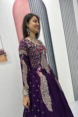 Woman wearing a purple embroidered traditional outfit with a white background