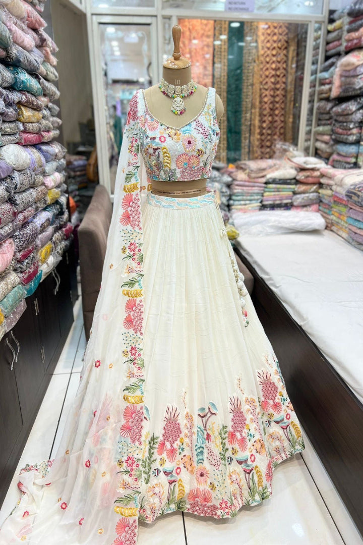 Floral embroidered lehenga on a mannequin in a fabric store.