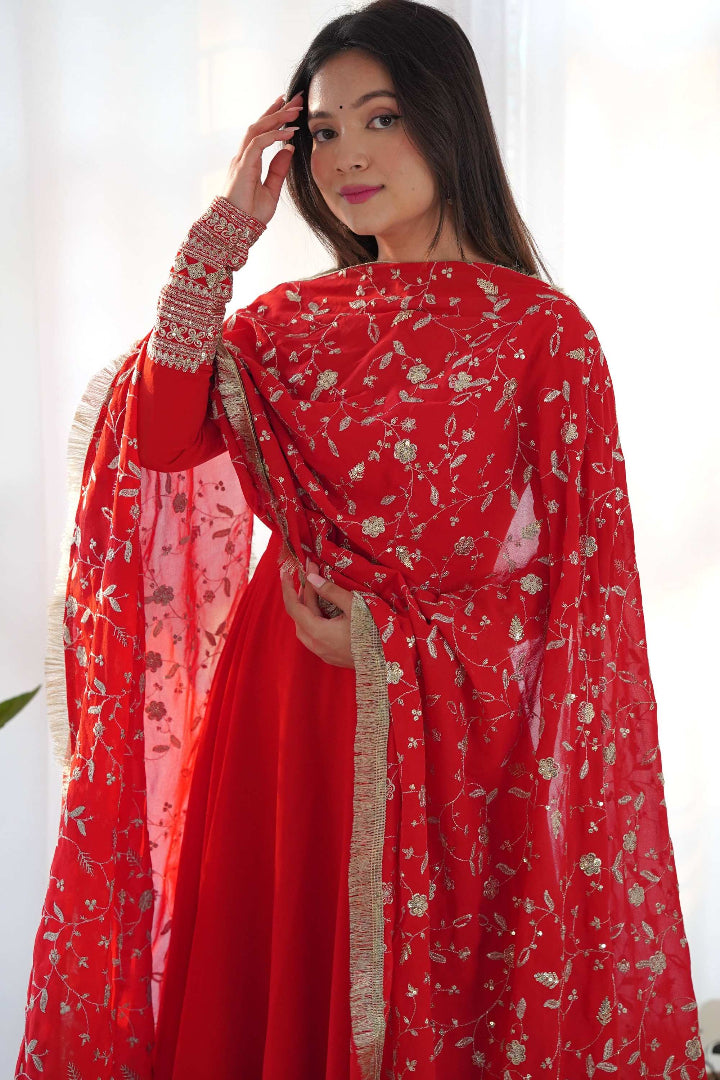 Woman wearing a red traditional outfit with floral patterns against a white background