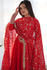 Woman wearing a red traditional outfit with floral patterns against a white background