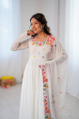 A woman wearing a long white embroidered dress 
